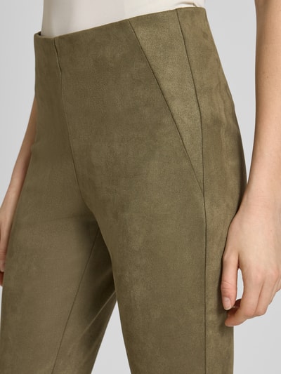 Kobiece modelka nosi Slim Fit Hose in verkürzter Passform von Christian Berg Woman, zielony kolor, welurowa faktura, elastyczny materiał, krój slim fit, szerokość w rozmiarze 36: 37 cm, długość wewnętrzna nogawki w rozmiarze 36: 73 cm, zbliżenie na górną część nóg