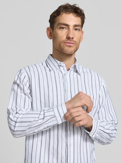 Mannelijk model draagt Regular Fit Leinenhemd aus Baumwoll-Leinen-Mix Modell 'CLAY' van SELECTED HOMME met all-over streeppatroon, Kent-kraag, lange mouwen en verstelbare manchetten, materiaalmix in wit en blauw, Nahaufnahme bovenlichaam.