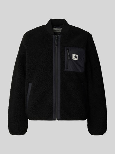 Produktfoto, Fleecejacke mit Zweiwege-Reißverschluss Modell 'Janet' von Carhartt Work In Progress, czarny kolor, tkanina typu teddy, krój regular fit, stójka, kieszenie z przodu, kieszeń na piersi, detal z logo, długość tyłu w rozmiarze S 80 cm, szerokość ramion w rozmiarze S 38 cm, szerokość w rozmiarze S 52 cm, długość rękawa w rozmiarze S 62 cm