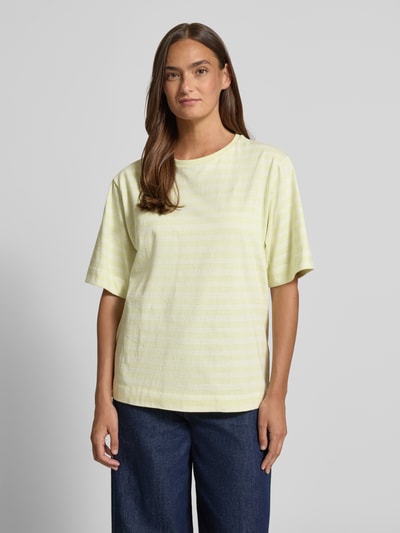 Frauenmodel trägt Oversized T-Shirt aus reiner Baumwolle Modell 'C_EREGULAR_STRIPE' von BOSS Orange, gelb-weiß gestreift, Rundhals, Jersey, kurzarm, Allover-Muster, Label Stitching, Ganzkörperansicht von vorne.