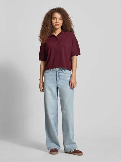 Kobiece model prezentuje Boxy Fit T-Shirt aus Baumwoll-Mix od Marc O'Polo Denim, efekt: jednolity kolor, pudełkowy krój, krój krótki, kołnierzyk polo, krótki rękaw, zakończenie rękawów i wykończenie: prążkowane z zrolowanym brzegiem, wykończenie materiału: frota, materiał: mieszanka bawełny. Ganzkörperansicht von vorne.