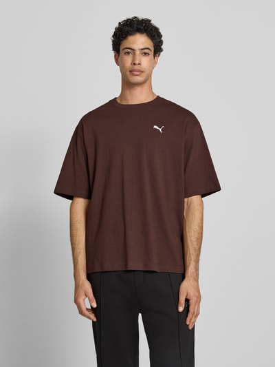 Mannmodel draagt T-shirt met ronde hals van PUMA PERFORMANCE in bruin, puur katoen, relaxed fit, logoprint, ruglengte maat M 69 cm, Ganzkörperansicht van voren.
