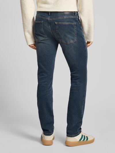 Männermodel trägt Slim Fit Jeans aus Baumwoll-Mix Modell 'LOOM' von Only & Sons in Dunkelblau mit 5-Pocket-Design, Ganzkörperansicht Rückansicht.