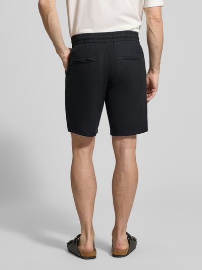 Männermodel trägt Shorts aus Leinen-Baumwoll-Mix Modell 'barton' von Matinique in Dunkelblau, elastischer Bund, Regular Fit, Ganzkörperansicht Rückansicht. Bundweite 43 cm, Innenbeinlänge 21 cm, Tunnelzug.