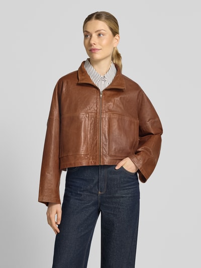 Vrouwenmodel draagt bruine dames leren jas met ritssluiting Model 'ELSTOW' van DRYKORN, relaxed fit, opstaande kraag, echt leer, full body voorkant.