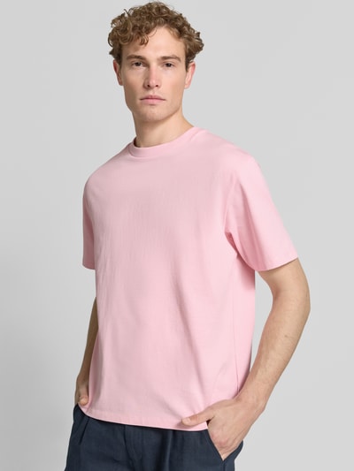 Männermodel trägt Oversized T-Shirt mit Rundhalsausschnitt von Lindbergh in Rosa aus Reine Baumwolle, Rückenlänge 69 cm bei Größe M, Ganzkörperansicht von vorne.