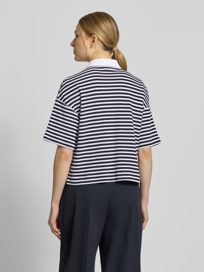 Frauenmodel trägt Relaxed Fit Oberteil in Strick-Optik mit Polokragen von Marc Cain aus Reine Baumwolle, Rückenlänge 54 cm, Streifenmuster, Ganzkörperansicht Rückansicht.