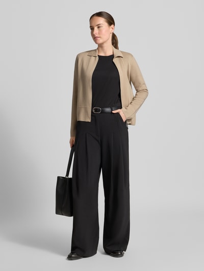 Frauenmodel trägt Strickjacke aus reiner Schurwolle Modell 'SNACK' von MM by Max Mara in Beige, taillierte Passform, Ganzkörperansicht von vorne.