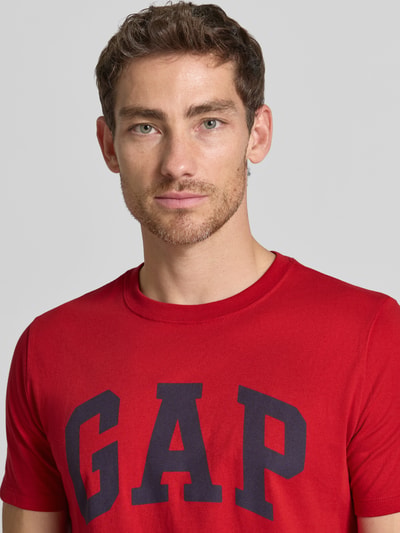 Männermodel trägt T-Shirt mit Logo-Print und Rundhalsausschnitt van GAP in rood, puur katoen, regular fit, logoprint, ruglengte maat M 67 cm, Nahaufnahme Oberkörper