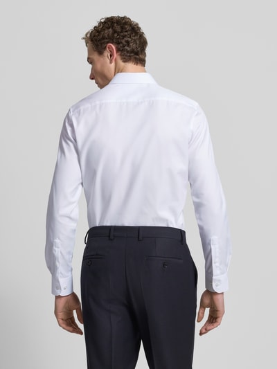 Männermodel trägt Slim Fit Businesshemd aus Twill von Eterna, reine Baumwolle, Haifischkragen, Knopfleiste, feine Webstruktur, Blickdicht, Ganzkörperansicht Rückansicht.