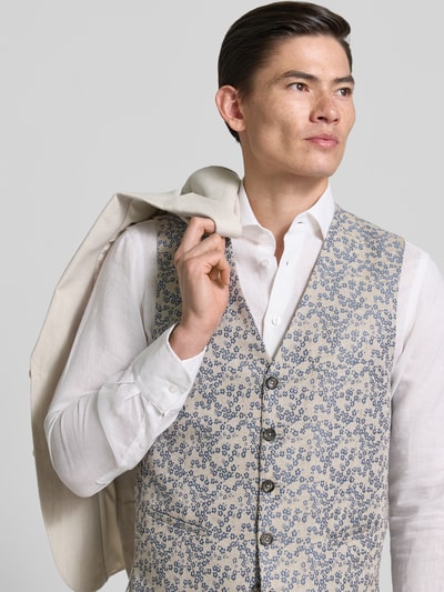 Męski model nosi Regular Fit Weste mit floralem Allover-Stitching von CG - Club of Gents, kremowe i niebieskie odcienie, tekstura kwiatowa, materiał mieszany z domieszką bawełny, krój regular fit, pasplowane kieszenie, pełny rząd guzików, długość tyłu w rozmiarze 50: 62 cm, szerokość ramion w rozmiarze 50: 39 cm, szerokość klatki piersiowej w rozmiarze 50: 60 cm, całkowity widok z przodu.