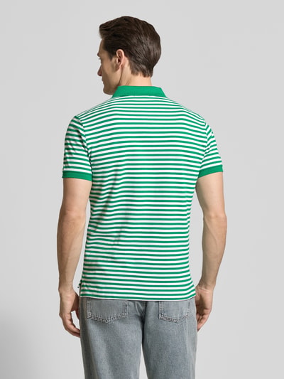 Männermodel trägt Slim Fit Poloshirt aus reiner Baumwolle von Polo Ralph Lauren, Two-Tone-Optik, gestreift, Logo-Detail, Piqué-Textur, Ganzkörperansicht Rückansicht.
