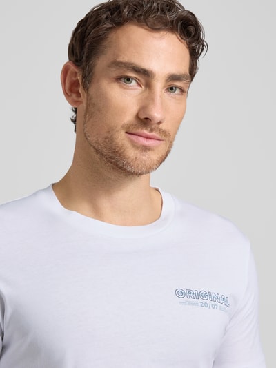 Männermodel trägt Regular Fit T-Shirt aus reiner Baumwolle von Tom Tailor Denim, weiß, kleiner Label-Schriftzug, Nahaufnahme Oberkörper.