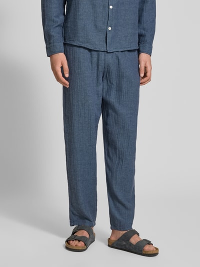 Männermodel trägt Hose aus Leinen-Baumwoll-Mix mit elastischem Bund von Redefined Rebel, Relaxed-Fit, Ganzkörperansicht von vorne.