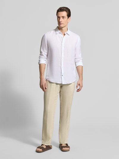 Męskki model nosi Straight Fit Leinenhose aus reinen Leinen Modell 'Lynx' od Mmx w kolorze beżowym, kieszenie z tyłu, zapięcie na guzik i zamek, szerokość w rozmiarze 32/32: 43 cm, długość nogawki wewnętrznej: 81 cm, pełny widok z przodu.