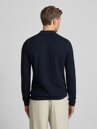 Männermodel trägt einen dunkelblauen Strickpullover mit Umlegekragen Modell 'Galdino' von JOOP! Collection im Baumwoll-Mix, Rückansicht.