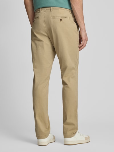 Männermodel trägt Slim Fit Chino mit Eingrifftaschen von GAP, beigefarbener Baumwoll-Elasthan-Mix, Ganzkörperansicht Rückansicht.