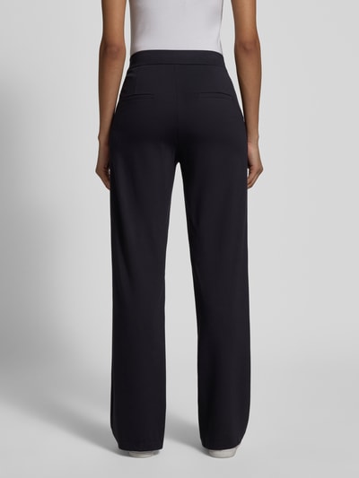 Vrouwenmodel draagt Regular Fit stoffen broek met viscose van Cambio, elastische band, siernaden, achterzakken, geheel van achteren.