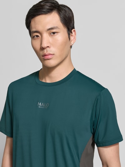 Männermodel trägt Herren T-Shirt mit Logo Modell 'DIVISION' von HALO in Petrol, Material-Mix mit Stretch-Anteil, Nahaufnahme Oberkörper.