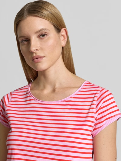 Frauenmodel trägt T-Shirt mit Streifenmuster und Rundhalsausschnitt von Christian Berg Woman in Rosa und Rot aus Reine Bio-Baumwolle, Regular-Fit, Nahaufnahme Oberkörper.