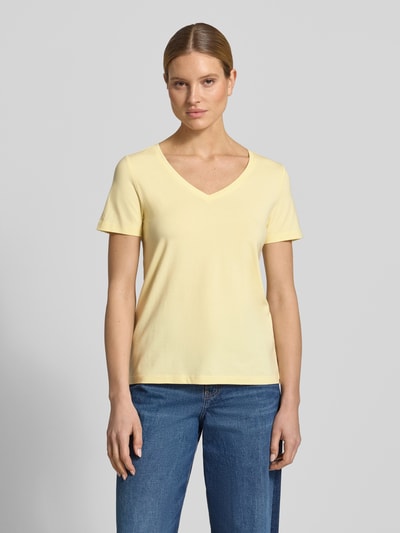 Modelka kobieca nosi Regular Fit T-Shirt aus Baumwoll-Mix von s.Oliver RED LABEL, efekt: jednolity kolor, dekolt w serek, krótki rękaw, wykończenie materiału: dżersej, mieszanka bawełny, jasny żółty, gładka tekstura, Ganzkörperansicht von vorne.