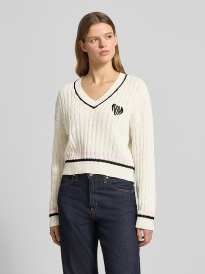 Frauenmodel trägt Strickpullover mit Zopfmuster und V-Ausschnitt Modell 'MAKI' von Noisy May, Baumwoll-Mix, Regular-Fit, Ganzkörperansicht von vorne.