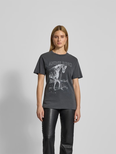 Frauenmodel trägt T-Shirt mit Logo-Print von Anine Bing aus reine Baumwolle, taillierte Passform, Rundhalsausschnitt, Ganzkörperansicht von vorne.