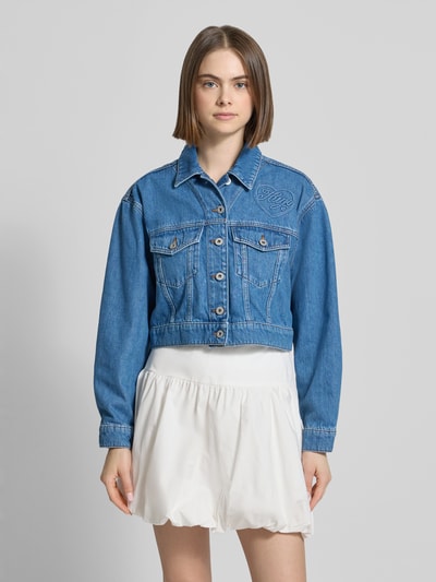 Frauenmodel trägt Regular Fit Jeansjacke Baumwoll-Mix Modell 'GALATEA_B' von Hugo Blue in Denim-Optik mit Pattentaschen, Ganzkörperansicht von vorne.