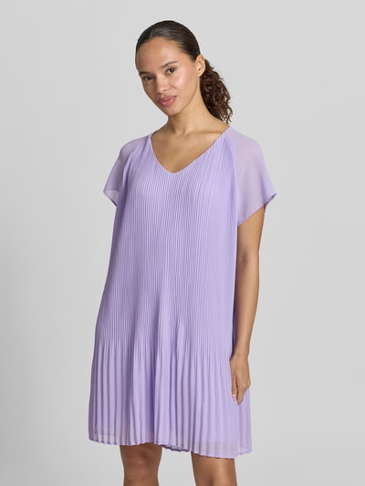 Frauenmodel trägt knielanges Cocktailkleid mit Plisseefalten Modell 'Inken' von GUIDO MARIA KRETSCHMER WOMAN, Chiffon, V-Ausschnitt, fliederfarben, Straight Fit, Ganzkörperansicht von vorne.