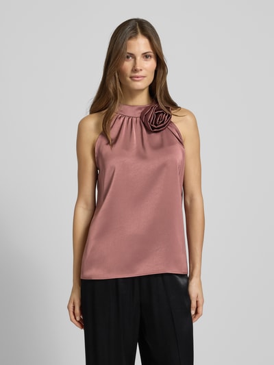 Frauenmodel trägt Blusentop aus Satin mit floraler Applikation Modell 'Rosette' von Neo Noir in Rosé mit Regular-Fit und Neckholder, Nahaufnahme Oberkörper.