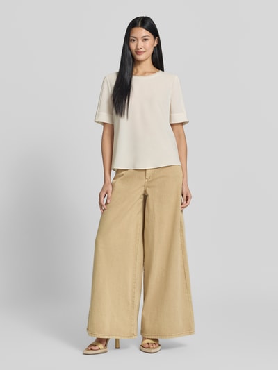 Frauenmodel trägt Blusenshirt mit Rundhalsausschnitt von Marc Cain in Beige mit schimmerndem Kontraststreifen, Chiffon, Regular Fit; Ganzkörperansicht von vorne.