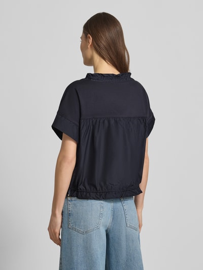 Kobiece modelka nosi t-shirt z wpuszczaną kieszenią przy dole 'T-Shirt mit Eingrifftasche am Saum' od Marc Cain, kolor granatowy, mieszanka bawełny i elastanu, luźny krój, okrągły dekolt z tunelem, pas z tunelem, długość tyłu w rozmiarze 36: 51 cm, widok całej sylwetki z tyłu.