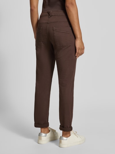 Frauenmodel trägt Relaxed Fit Chino aus Baumwoll-Mix von Tom Tailor in Dunkelbraun, glatte Textur, Damen Chino, Ganzkörperansicht Rückansicht.