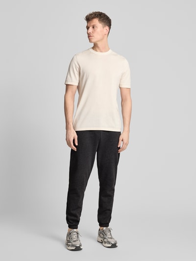 Męski model trägt Sweatpants mit Logo und elastischem Bund von GAP, czarne, mieszanka bawełny, krój regular fit, logo, całkowity widok z przodu