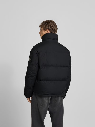 Mannenmodel draagt Steppjacke mit Stehkragen van Moose Knuckles in zwart, regular fit, met steekzakken, verborgen rits, ganzkörperansicht rückansicht.