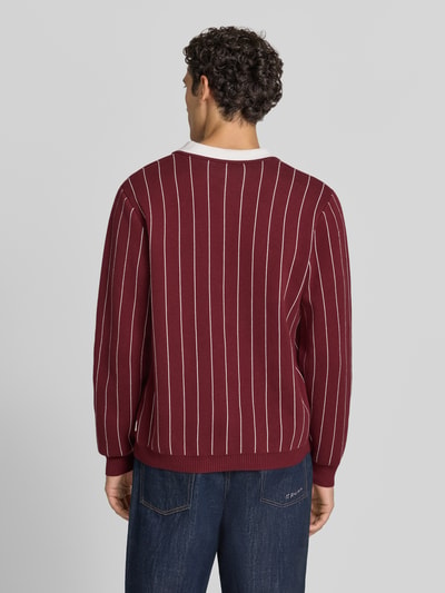 Männermodel trägt Regular Fit Poloshirt mit Logo-Stitching von Les Deux in Bordeaux mit weißen Streifen, Ganzkörperansicht Rückansicht. Rückenlänge bei Größe M: 68 cm, reine Baumwolle, gerippte Abschlüsse.
