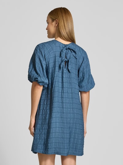 Frauenmodel trägt Minikleid aus Viskose-Mix mit Ballonärmel von Jake*s Casual in Blau, gerader Schnitt, strukturierte Textur, Ganzkörperansicht Rückansicht. Rückenlänge 85 cm, Brustweite 45 cm, Ärmellänge 43 cm bei Größe 36, Rundhalsausschnitt, rückseitiger Schlüsselloch-Ausschnitt mit Haken.