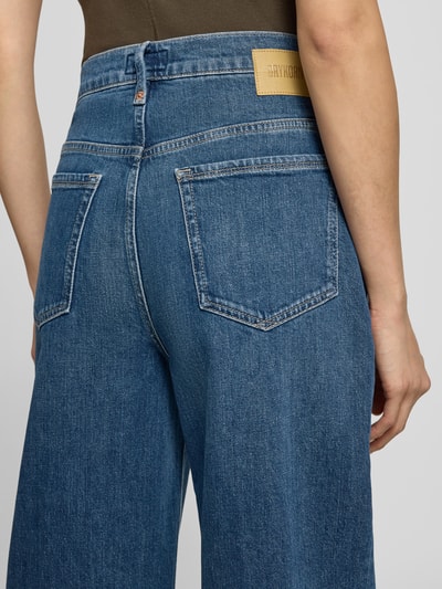 Frauenmodel trägt Jeans aus Baumwoll-Mix Modell 'Flown' von DRYKORN in mittlerem Blau, lockere Passform, Detailaufnahme Rückansicht. Damen Jeans aus elastischem Baumwoll-Mix, verkürzte Passform, 5-Pocket-Design, Knopf- und Reißverschluss, Bundweite 39 cm, Innenbeinlänge 68 cm.