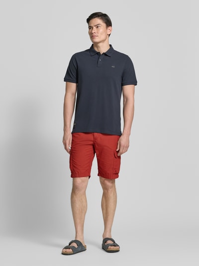 Männermodel trägt Bermudas mit Cargotaschen von camel active in rood, regular fit, puur katoen, steekzakken, cargozakken, labeldetail, bandwijdte maat 32: 44 cm, binnenbeenlengte maat 32: 26 cm, ganzkörperansicht van voren.