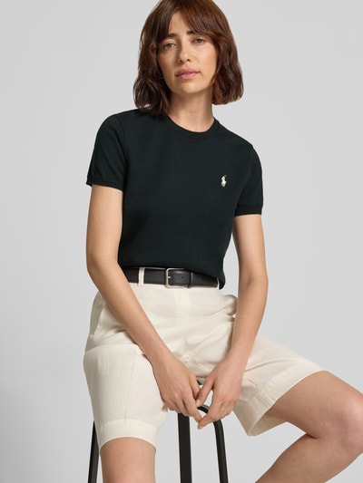 Modelka nosi Slim Fit Strickshirt aus Baumwoll-Mix von Polo Ralph Lauren, jednokolorowy efekt, krój slim fit, wyhaftowane logo, okrągły dekolt, krótki rękaw, prążkowane wykończenia, drobny splot, mieszanka bawełny. Nahaufnahme górnej części ciała z przodu.