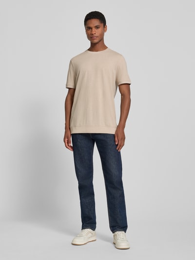 Männermodel trägt Regular Fit T-Shirt aus Baumwoll-Mix von s.Oliver RED LABEL in Beige zu Jeans, neutrale Farben, Ganzkörperansicht von vorne.