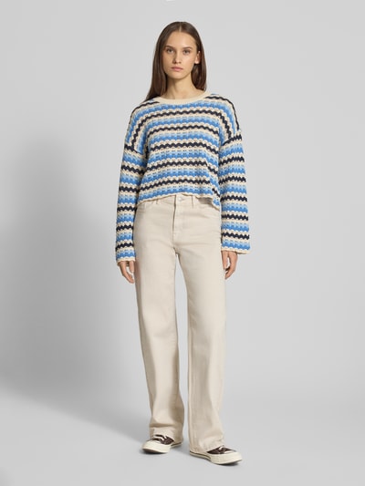 Frauenmodel trägt Regular Fit Strickpullover aus Baumwoll-Mix Modell 'ASA' von ONLY, mehrfarbig, gestreift, Lochstrickmuster, Cropped, Muschelsaum, Ganzkörperansicht von vorne.