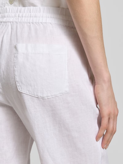 Frauenmodel trägt Leinenhose mit elastischem Bund und Gesäßtaschen von Christian Berg Woman in Weiß, reine Leinen, Nahaufnahme Gesäßbereich.