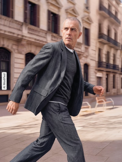 Männermodel trägt Modern Fit Anzughose aus Schurwoll-Leinen-Mix Modell 'FLIPS251X' von HUGO w Melanż, splot twill, szlufki, zapięcie na guzik i zakryty zamek błyskawiczny, boczne kieszenie, kieszenie z tyłu, długość regular, średni stan, wykończenie materiału: mieszanka żywej wełny i lnu, Ganzkörperansicht von vorne, KI-modifiziertes Bild.