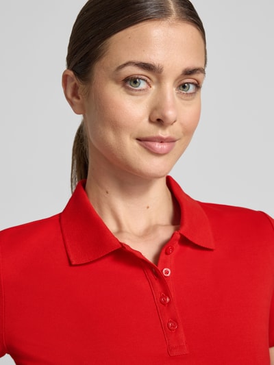 Frauenmodel trägt Regular Fit Poloshirt aus reiner Baumwolle von Tom Tailor in kräftigem Rot, glatte Struktur, Nahaufnahme Oberkörper, Damen Poloshirt von Tom Tailor.