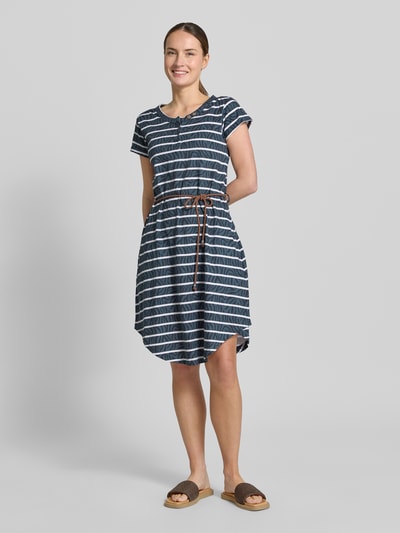 Frauenmodel trägt Knielanges T-Shirt-Kleid mit Bindegürtel von G.I.G.A. DX aus Reine Baumwolle, gestreiftes Muster, Ganzkörperansicht von vorne.