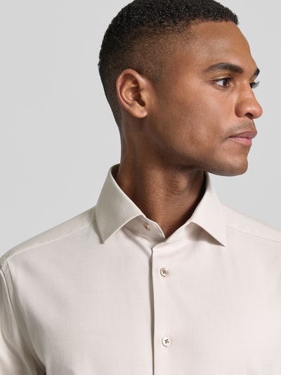 Męski model nosi Regular Fit Business-Hemd mit Kentkragen od OLYMP, bawełniany miks z domieszką stretchu, guzik, krój regular fit, Kent, długość tyłu w rozmiarze 40: 79 cm, szerokość ramion w rozmiarze 40: 46 cm, długość rękawa w rozmiarze 40: 65 cm, jasny kolor, tekstura gładka, zbliżenie na górną część ciała