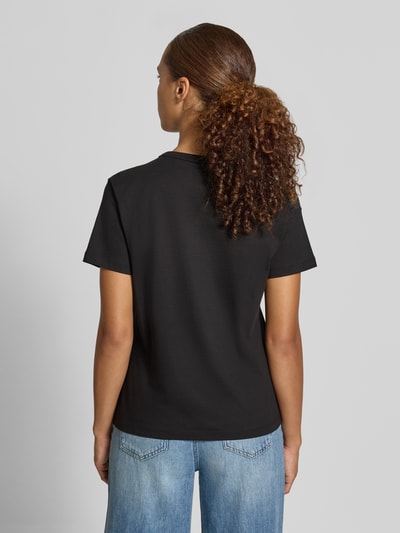 Frauenmodel trägt Regular Fit T-Shirt aus reiner Baumwolle Modell 'Damacia_9' von HUGO, schwarze Farbe, glatte Textur, Damen T-Shirt, Ganzkörperansicht Rückansicht.