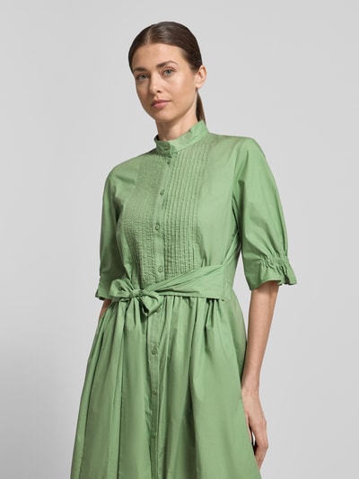 Frauenmodel trägt Midikleid mit Stehkragen und Bindegürtel von Luisa Cerano aus reiner Baumwolle in A-Linie, Nahaufnahme Oberkörper.