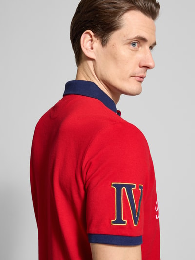 Männermodel trägt Regular Fit Poloshirt aus reiner Baumwolle von Polo Ralph Lauren in Rot, Piqué-Struktur, Label-Applikation, Nahaufnahme Oberkörper